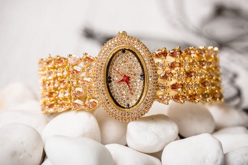 Free Gold Wristwatch with Diamonds on White Pebbles Stock Photo