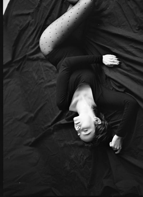 Woman in Black Long Sleeve Shirt Lying on Bed