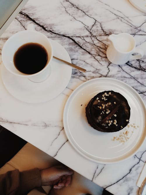 Free Overhead Shot of a Cup of Coffee Near a Chocolate Cake Stock Photo