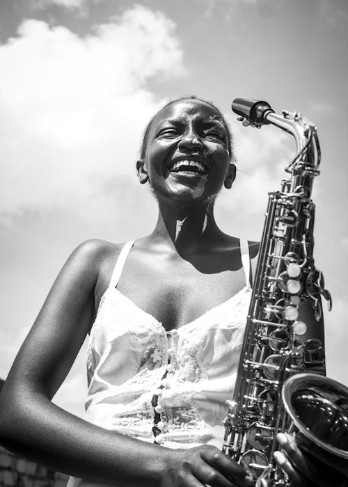 Black and White Portrait of Smiling Woman With Saxophone