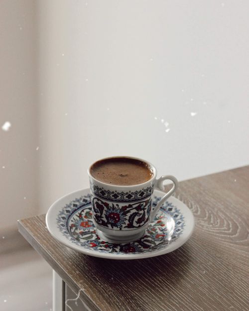 Free A beautifully decorated coffee cup on a wooden table in a serene indoor setting. Stock Photo