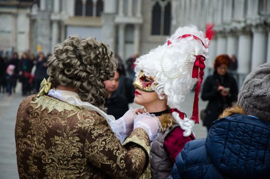Intricate costumes at a lively street festival capturing Venetian carnival spirit.