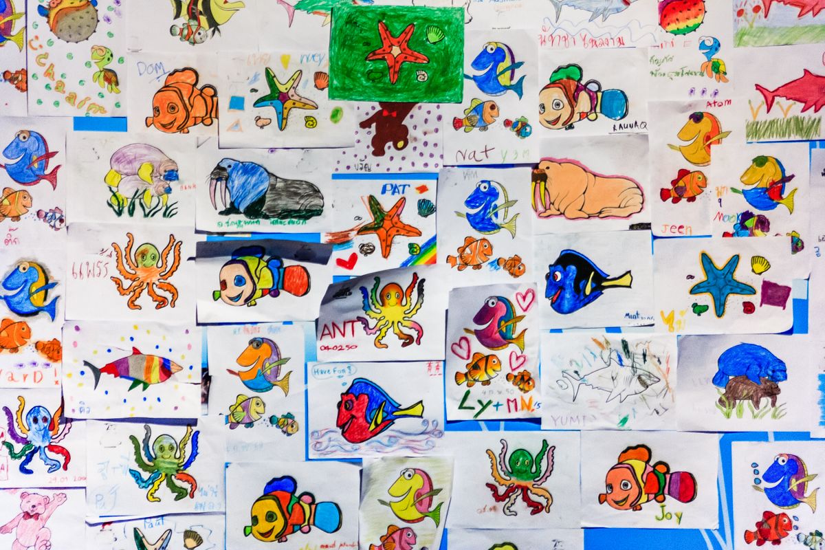 Colorful collage of children's drawings of fish and marine life