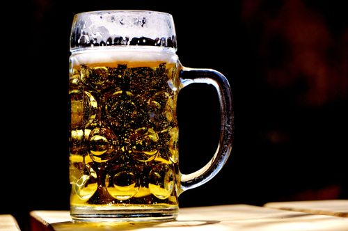 Free A high-contrast image of a beer mug with rich foam and bubbles against a dark background. Stock Photo