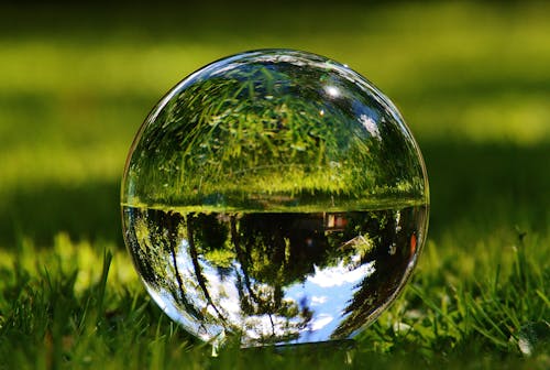 Free Reflection of Trees and Grass on a Glass Ball Stock Photo