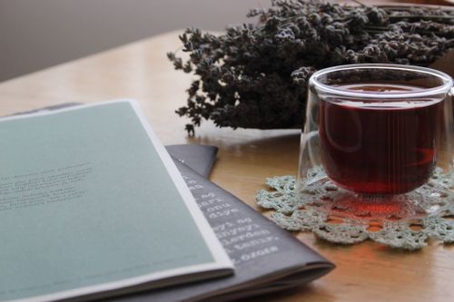 Free A calming setting with tea, lavender, and an open book on a wooden table. Stock Photo