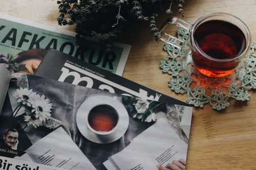 Free A warm setting with tea and magazines on a wooden table, perfect for relaxation. Stock Photo