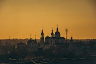 在橙色的日落天空下，大教堂的轮廓与塔和圆顶清晰可见