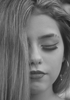 Elegant black and white portrait of a woman with eyes closed, showcasing serenity.