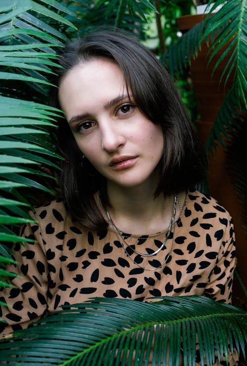 Portrait of Woman Standing among Palm Tree Leaves