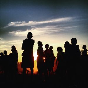 Crowd silhouetted against a sunset sky — photo by Keith Wako on Pexels