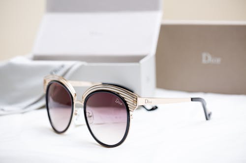 Gold Framed Sunglasses on White Surface