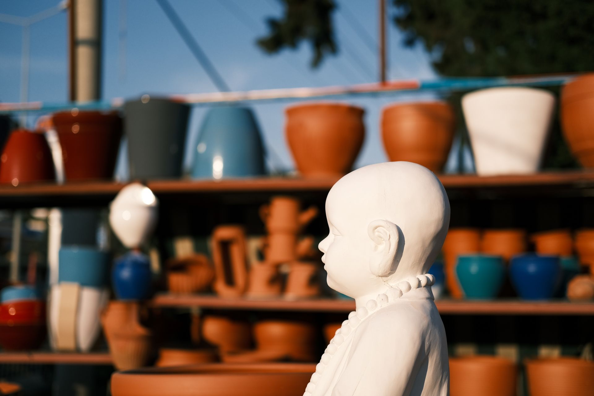 White Figurine Near the Clay Pots