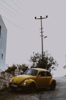 Retro yellow car parked on a winter street, capturing a vintage vibe with urban elements.