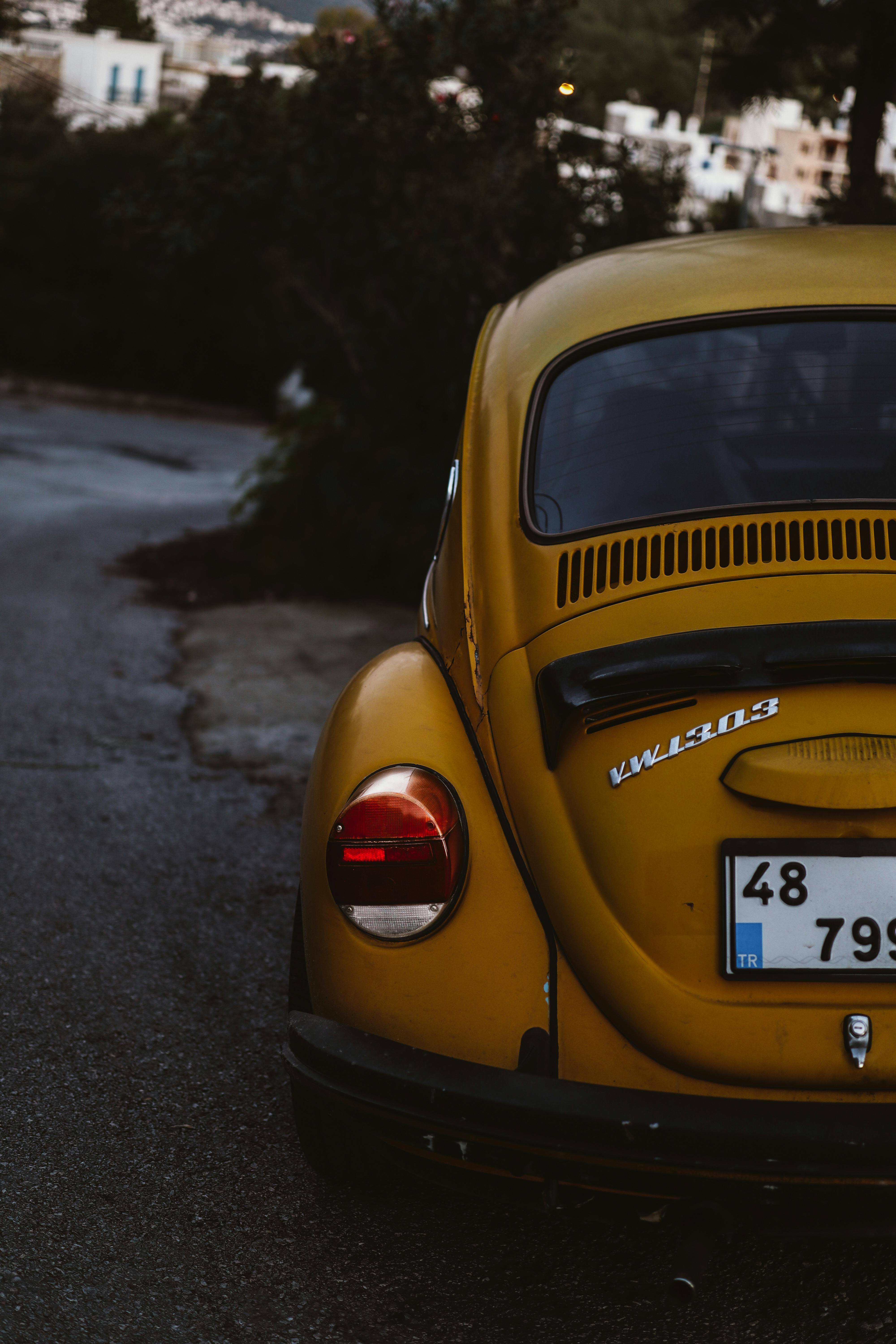 Rear view of classic yellow Volkswagen Beetle on winding road