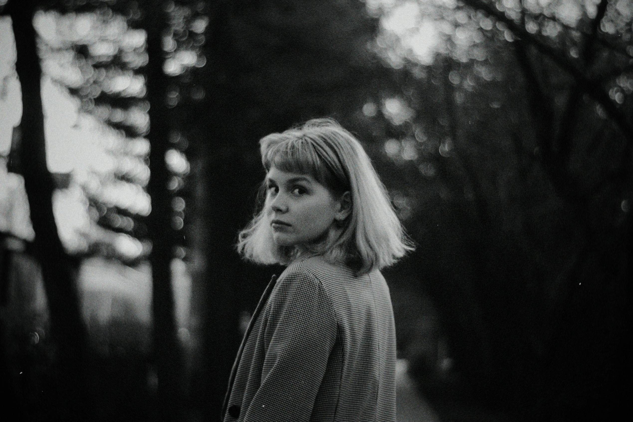 black and white portrait of young woman looking over shoulder