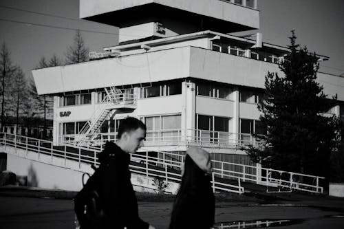 Grayscale Photo of a Couple Outside a Building