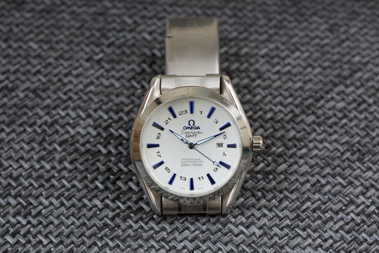 Silver Omega Wristwatch On Textured Surface