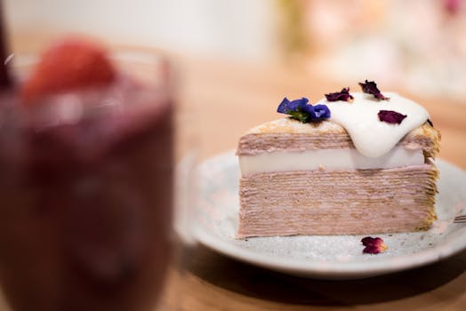 室内的盘子上摆放着切成薄片的分层绉纱蛋糕，上面装饰着奶油和花卉