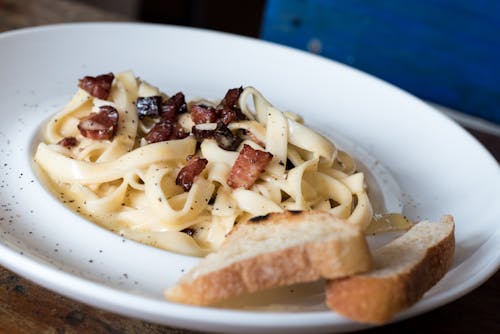 Pasta Dish Dengan Roti Di Piring Keramik Putih