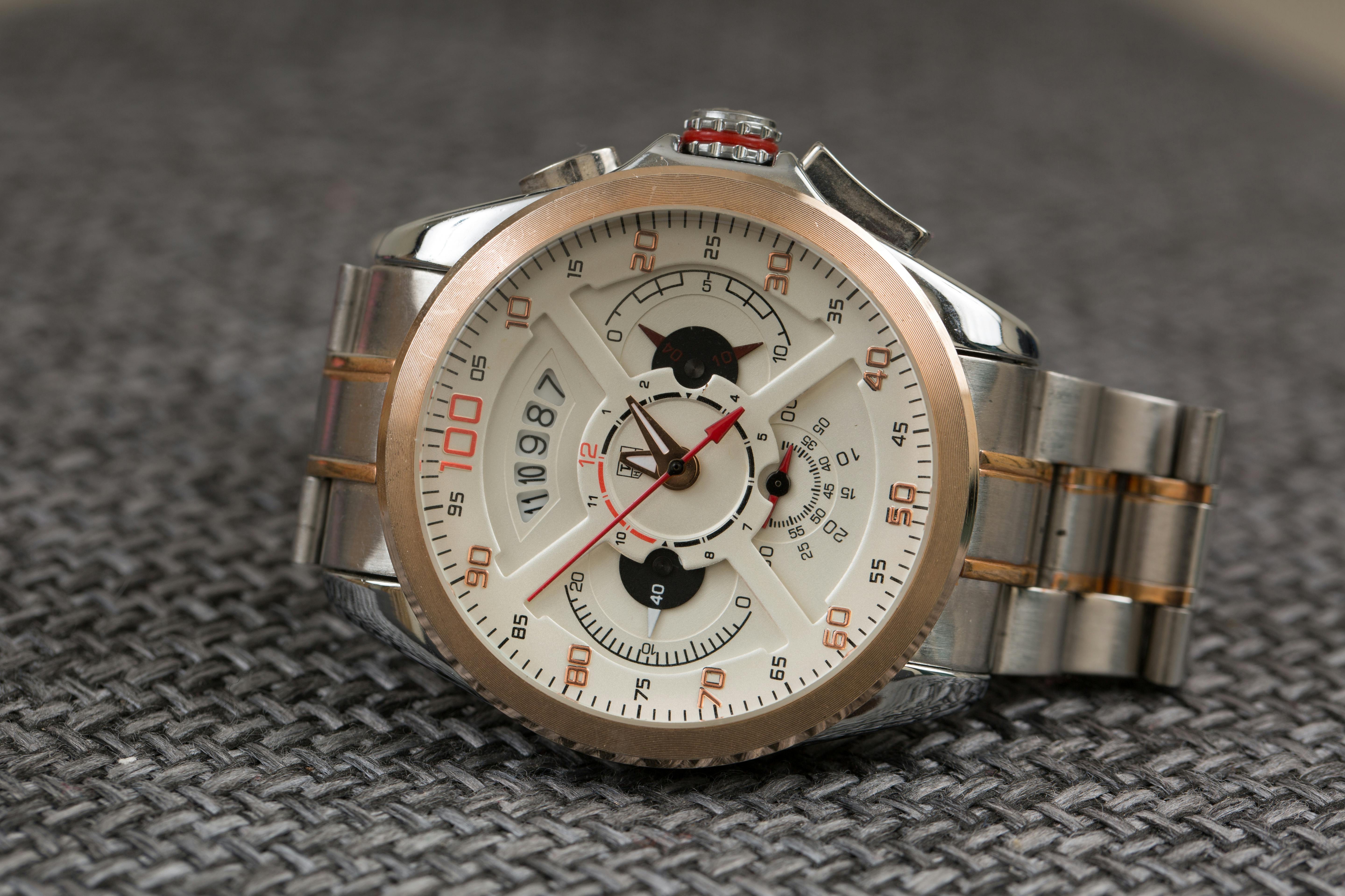 gold and silver chronograph watch in close up photography