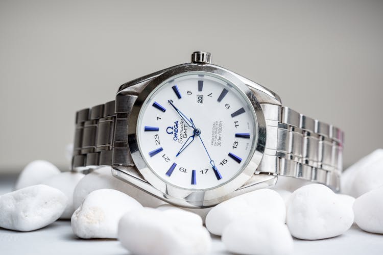 Silver Omega Watch On White Pebbles