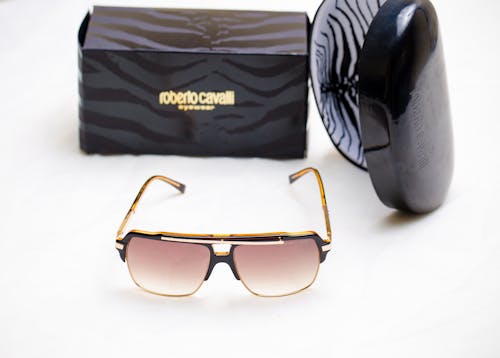 Brown Framed Sunglasses Beside Black and Gray Striped Bag