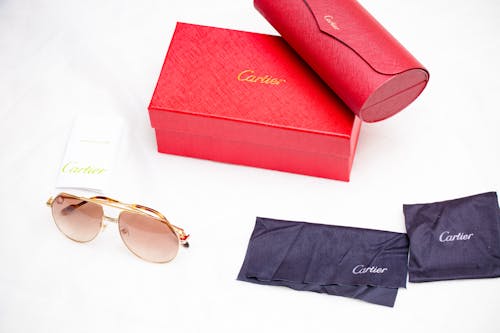 Red and Gold Framed Sunglasses Beside Red Box