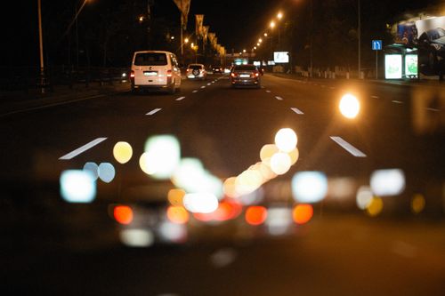 Free Nighttime city road with bokeh lights and vehicles in motion. Stock Photo