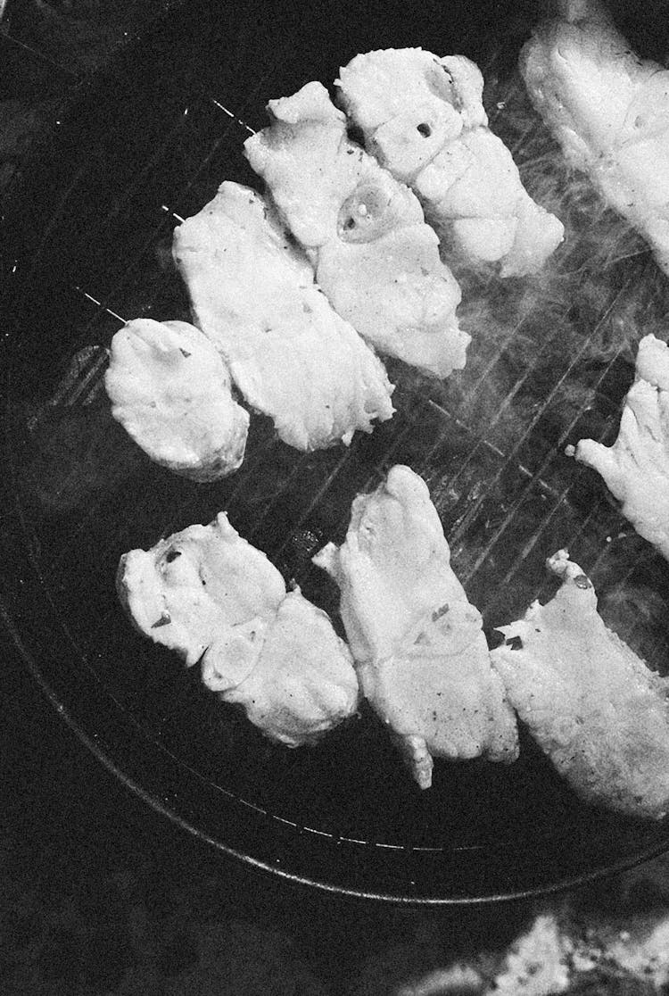 Black And White Photo Of Meat Cooking On Grill