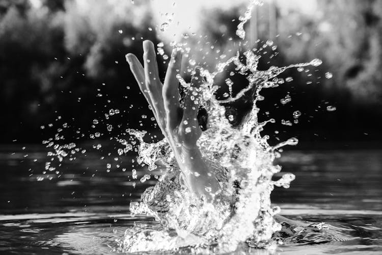 Grayscale Photo Of A Hand Coming Out Of Water