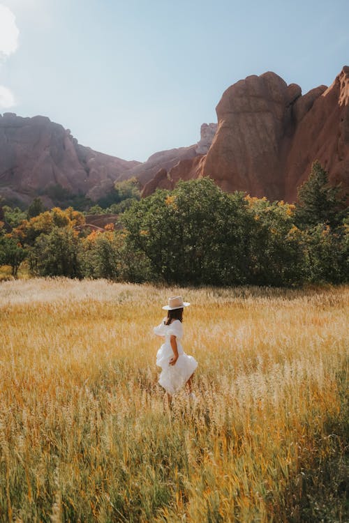 Free Woman in White Dress Walking Through Field Stock Photo