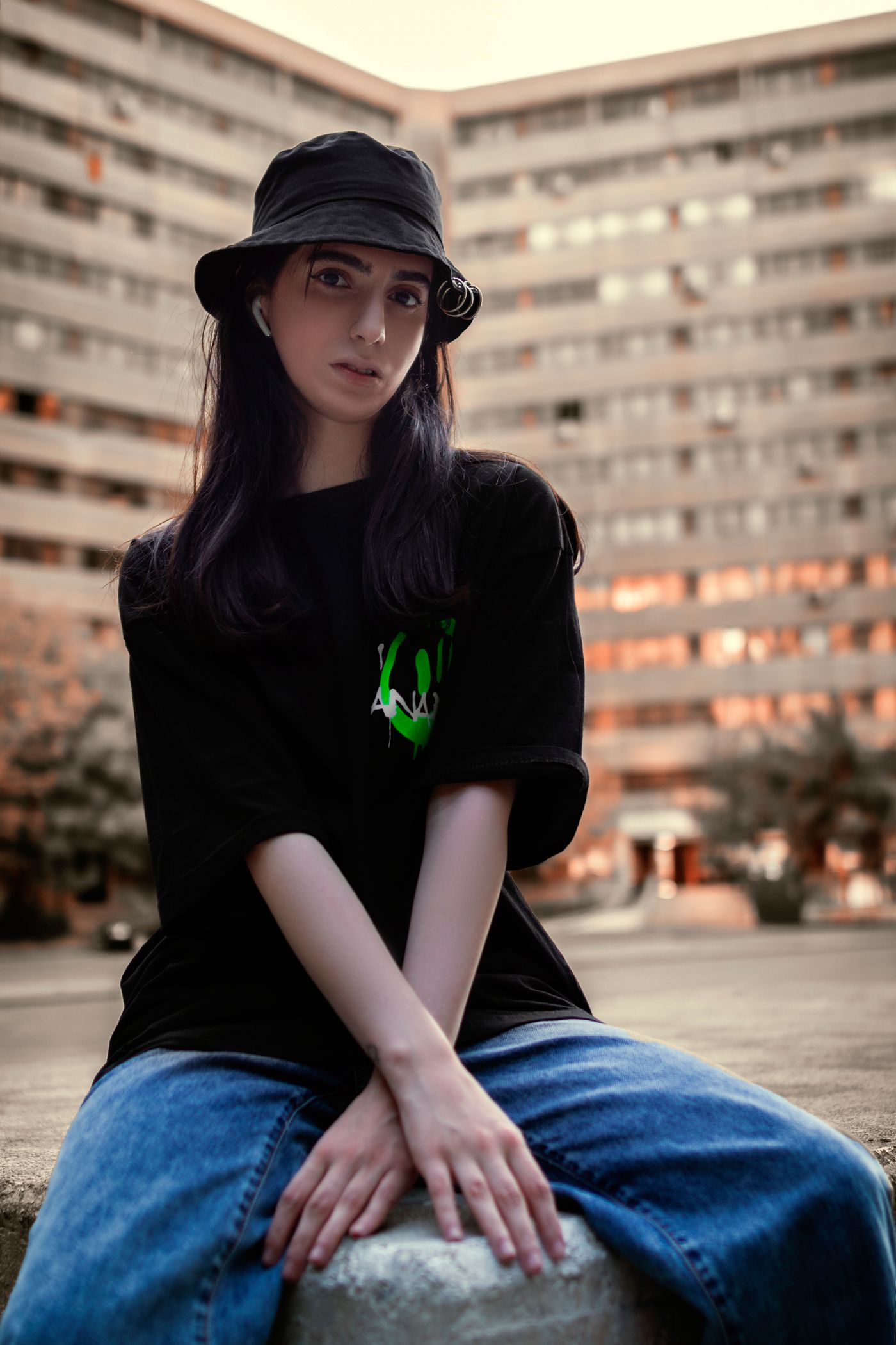 Moody urban portrait of a woman wearing a dark bucket hat