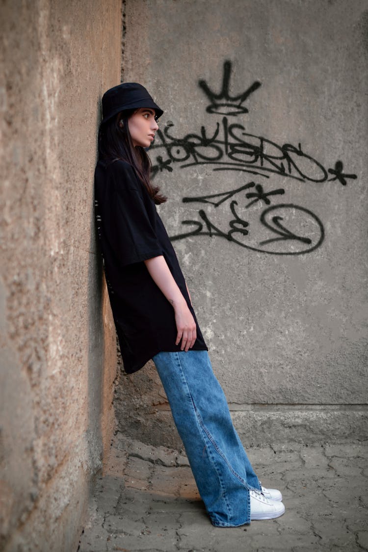 Side View Shot Of A Woman Leaning On The Wall While Looking Afar