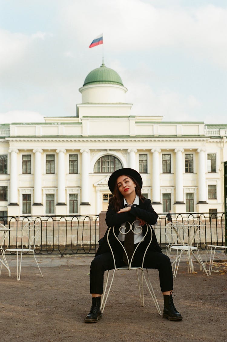 Woman Sitting On Chair In Front Of Russian Government Building