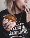 Woman in Black and White Crew Neck Shirt Holding Burger
