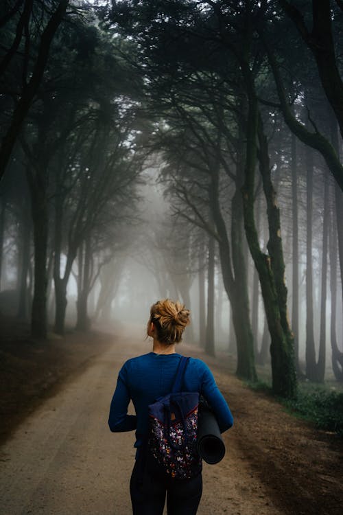 Woman Walking in Misty Forest