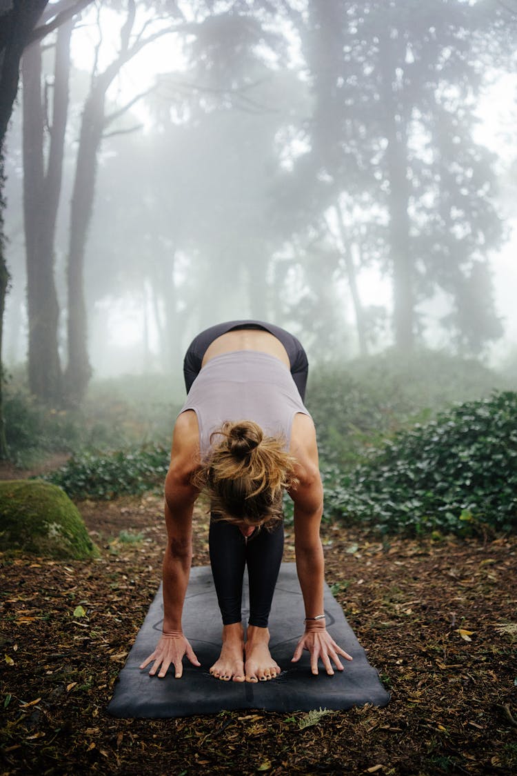 Woman Doing Yoga In Misty Forest