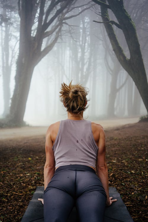 Woman Doing Yoga among Trees in Forest