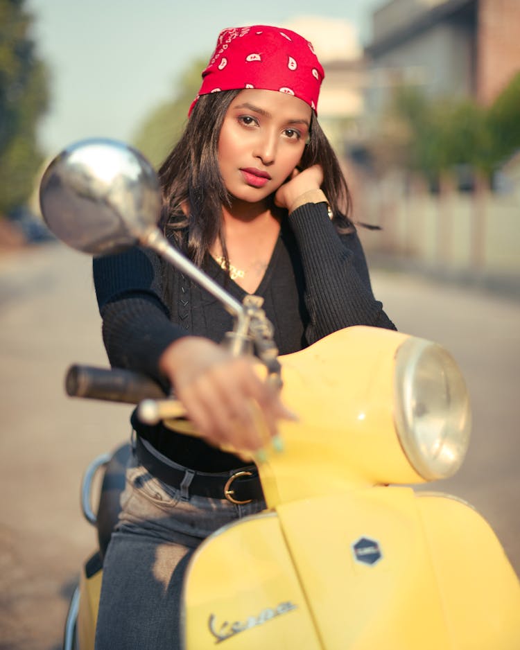 Woman In Red Bandana Sitting On A Yellow Vespa