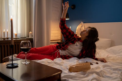 Woman Eating Chocolates in Bed on Valentines Day