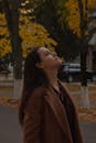 A Woman in Brown Coat Looking Up