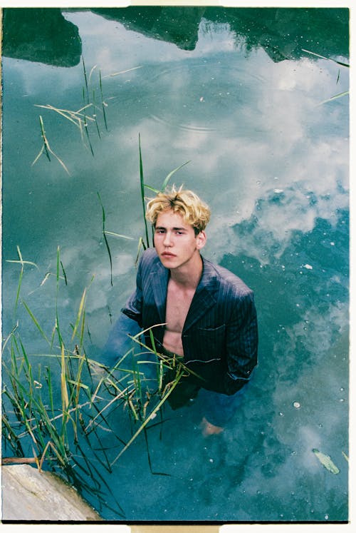 Blond Haired Man in Jacket Standing in Water
