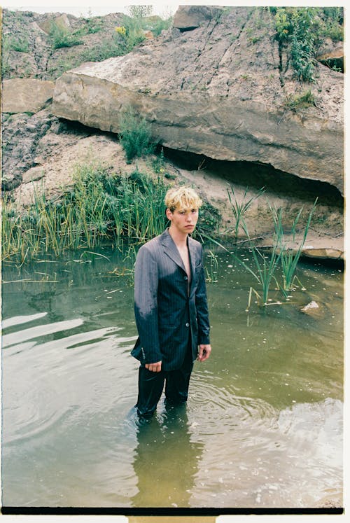 Blond Haired Man in Jacket Standing in Water