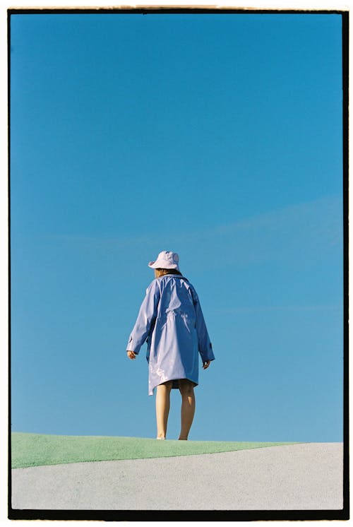 Free Woman in Blue Coat and Hat Against Sky Stock Photo