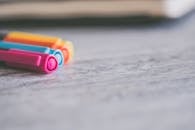 一张特写的充满活力的彩色笔，置于有纹理的木制书桌表面，适合办公室或艺术主题的理想场景