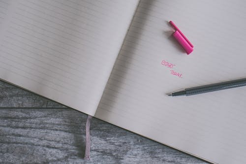 Free Pink Ballpoint Pen on White Ruled Paper Stock Photo