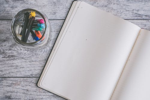 Free Photo of Blank Note Book Near Clear Jar Stock Photo