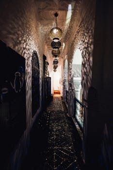昏暗的摩洛哥走廊里，挂着马拉喀什的传统灯笼，墙壁装饰华丽