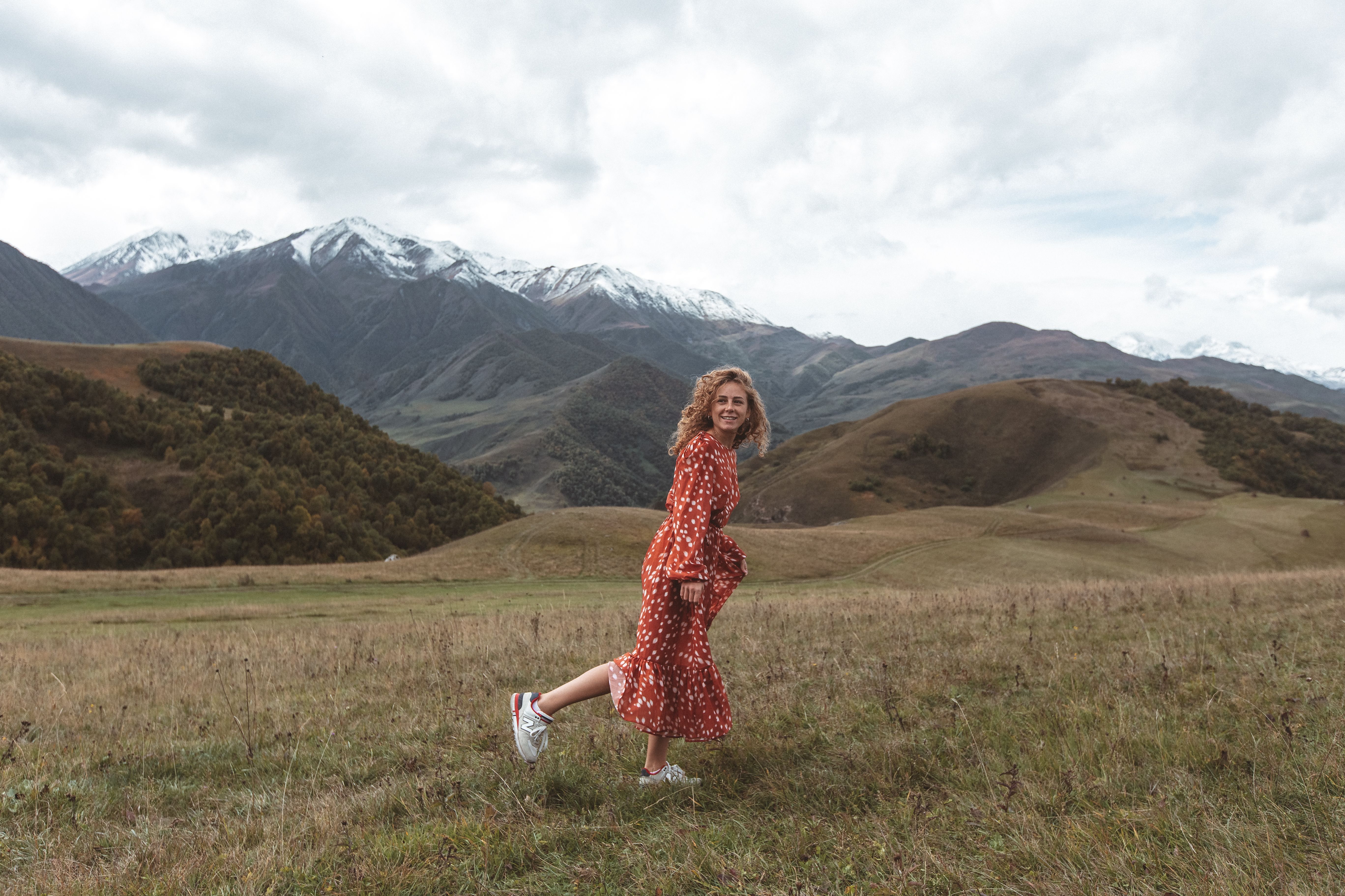 Woman in Red and White Dress Walking on Grass Field · Free Stock Photo